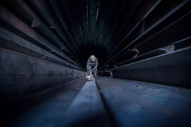 管道井中施工的仪表工人 管道井中施工的仪表工人